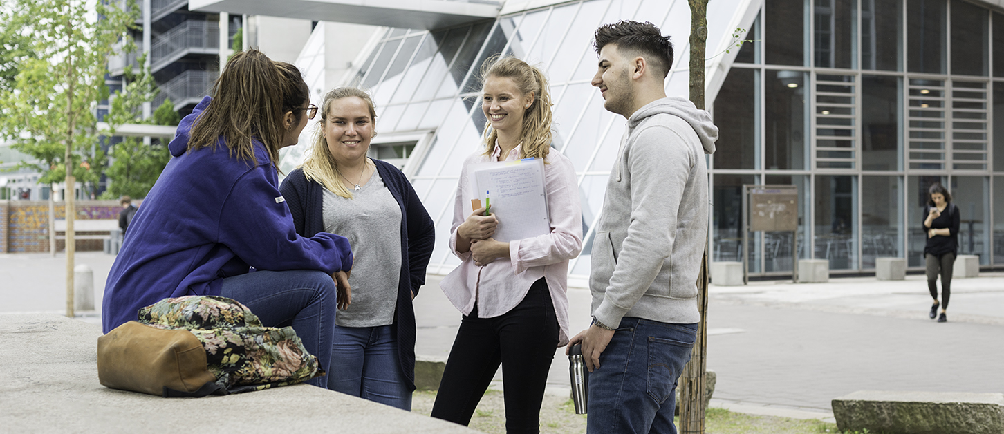 Hochschule für angewandte Wissenschaften Hamburg, vier Studierende vor Gebäude